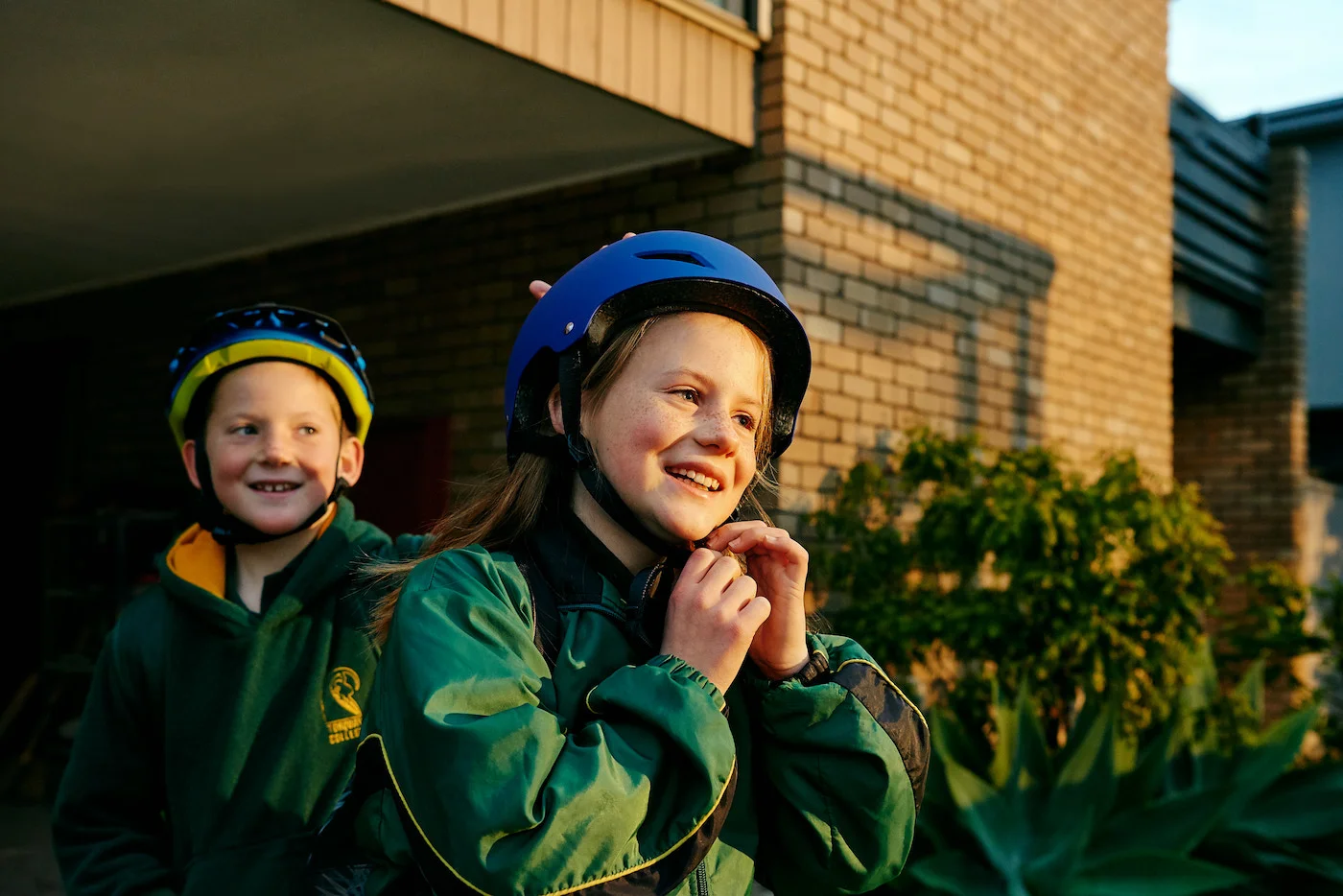 Ross' kids fitting their helmets before riding their bikes