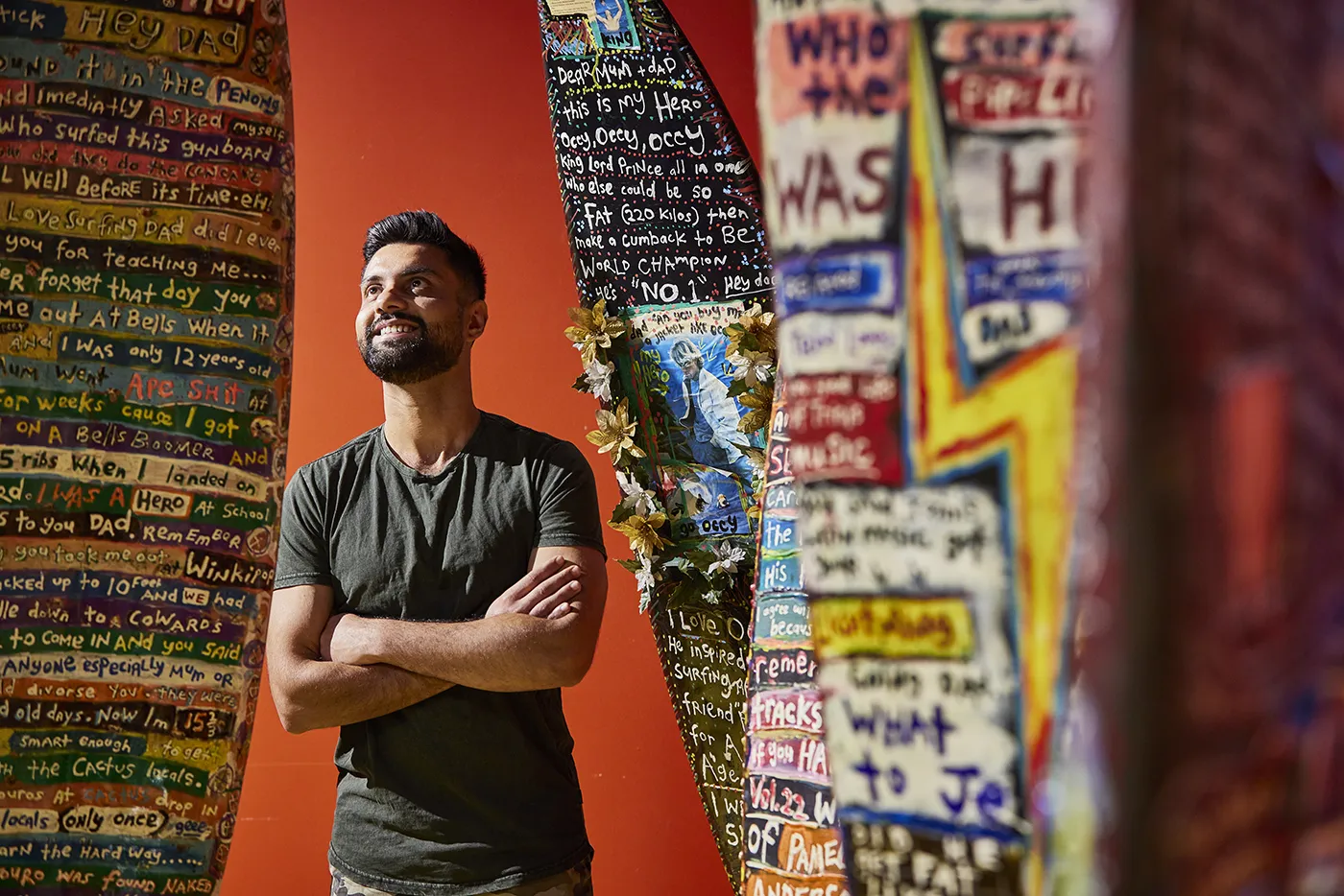 Man surrounded by decorated surfboards