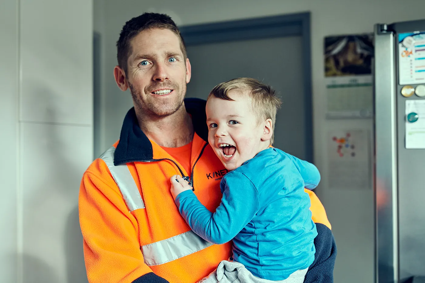 Man holding a boy at a workplace